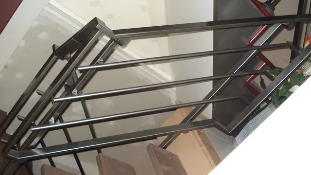 Stainless steel horizontal bar railing with a square top rail at an interior landing